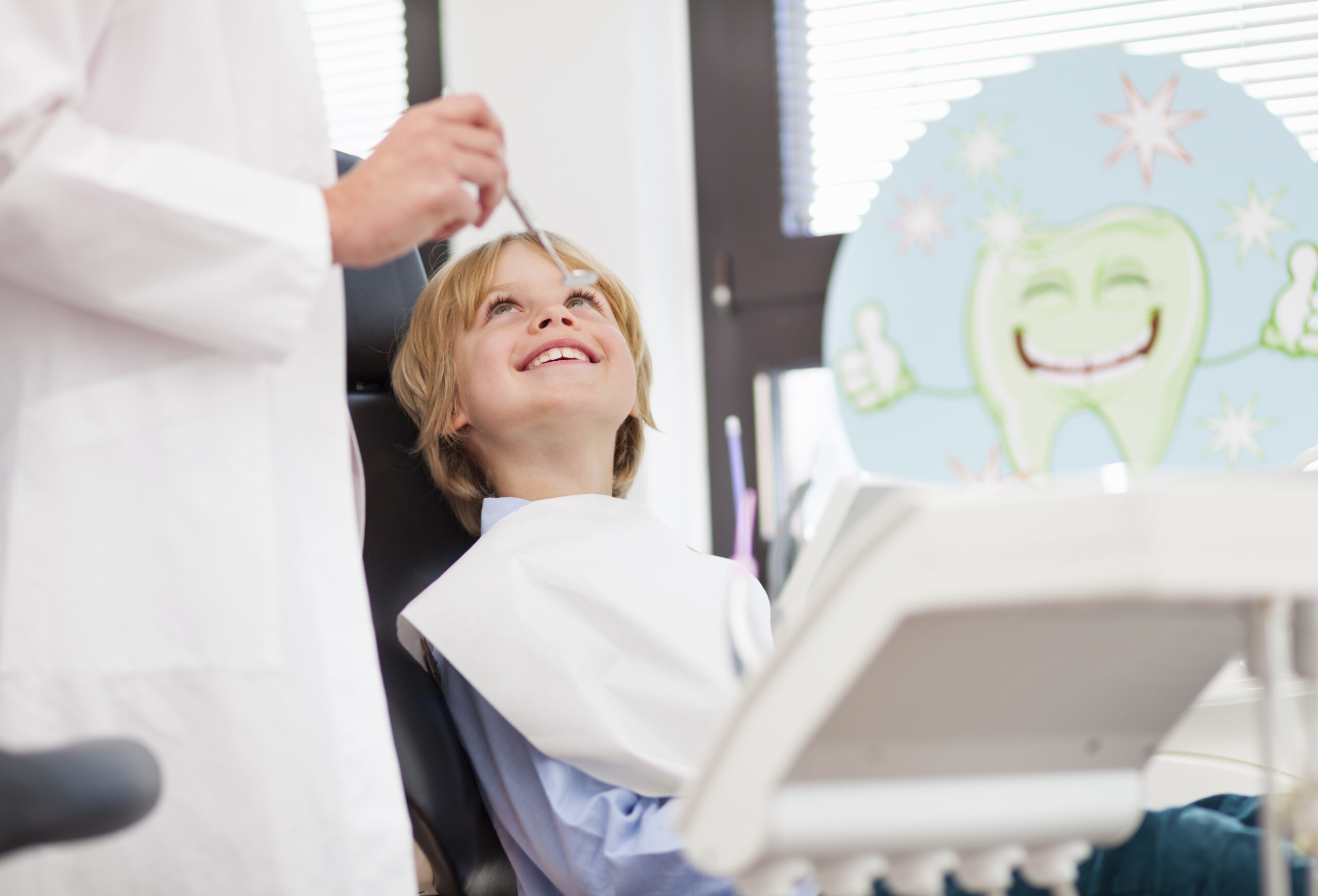Happy boy in dentists chair having check up.