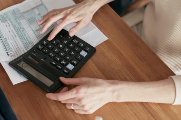 Persona que utiliza una calculadora para pagar facturas.
