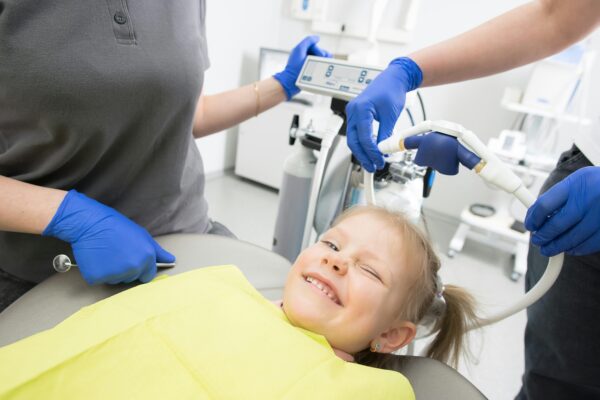 Niño feliz recibiendo tratamiento dental.